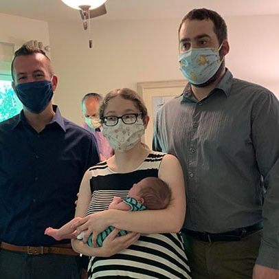 rabbi and a couple with baby at naming ceremony