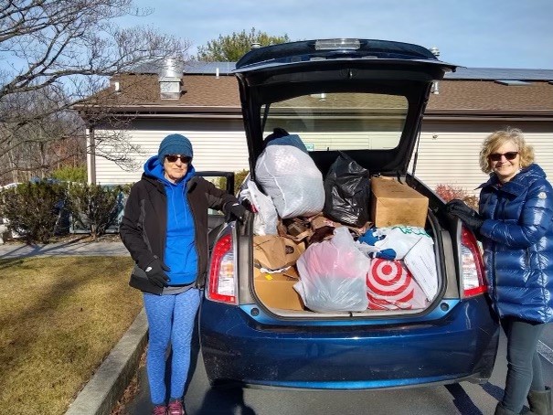 trunk of a car filled with clothes for a clothing drive