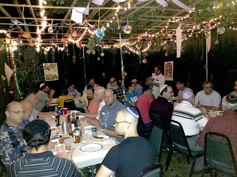 men eating in a sukkah